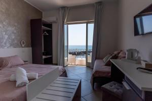 una camera con letto e vista sull'oceano di Teddu B&B a Giardini Naxos