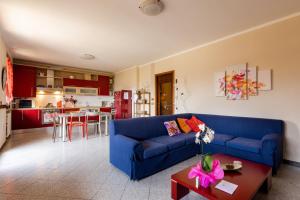 a living room with a blue couch and a kitchen at CASA ROSA & LUISA in Pozzolengo