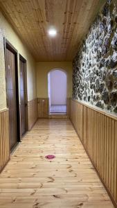 an empty room with a wooden floor and a wall at Mestiatour Guest House in Mestia