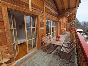 a balcony of a log cabin with chairs and windows at Apartment Ardève 13 by Interhome in Ovronnaz