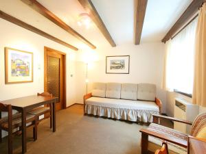 a room with a bed and a table and a window at Apartment Residenza Chesa Margun 14-1 by Interhome in Surlej