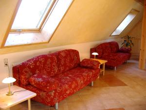 ein Wohnzimmer mit einem roten Sofa und 2 Fenstern in der Unterkunft Apartment Biohof Herrenweg-3 by Interhome in Dreimühlen