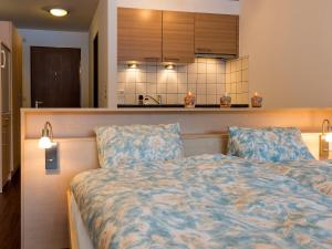 1 dormitorio con 1 cama y cocina en Apartment Amici-2 by Interhome, en Saas-Grund