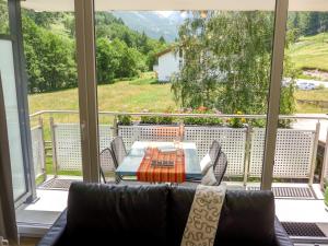 a living room with a couch and a table on a balcony at Apartment Amici-3 by Interhome in Saas-Grund