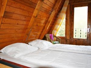 Bett in einem Zimmer mit einer Holzwand in der Unterkunft Chalet Nepumuk-2 by Interhome in Arendsee