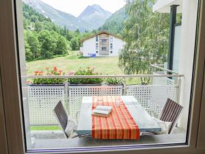 a table and chairs on a balcony with a view at Apartment Amici-4 by Interhome in Saas-Grund