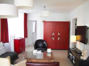 sala de estar con sofá y puerta roja en Apartment Wohnung 21 by Interhome en Davos