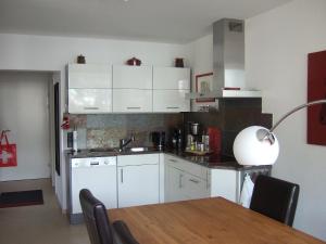 a kitchen with white cabinets and a table with a lamp at Apartment Promenade Wohnung 21 by Interhome in Davos