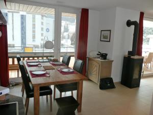 uma sala de jantar com uma mesa de madeira e cadeiras em Apartment Wohnung 21 by Interhome em Davos