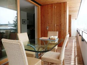 uma sala de jantar com uma mesa de vidro e cadeiras em Apartment Wohnung 21 by Interhome em Davos