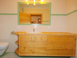 y baño con lavabo de madera y espejo. en Apartment Marina-3 by Interhome, en Mühlfeld
