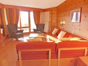 a living room with a bed and two chairs at Apartment Le Bristol B52 by Interhome in Villars-sur-Ollon