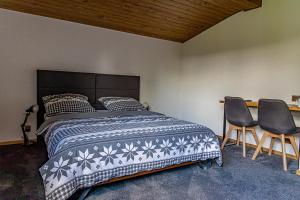 a bedroom with a bed and two chairs at Black Deer in Czarna Góra