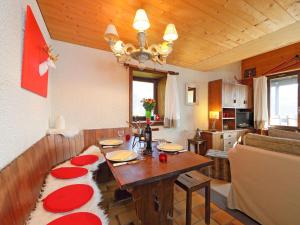 a living room with a table with red pillows on it at Apartment Les Petites Maraîches 132-389 by Interhome in Taveyannaz