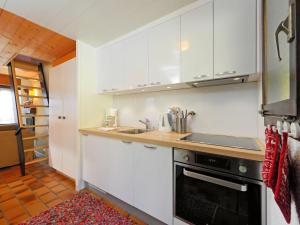 a kitchen with white cabinets and a stove top oven at Apartment Les Petites Maraîches 132-389 by Interhome in Taveyannaz