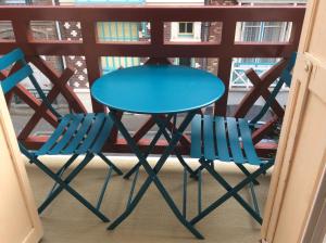 d'une table bleue et de deux chaises sur un balcon. dans l'établissement VILLA treize quartier balnéaire, à Mers-les-Bains