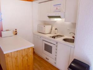małą kuchnię ze zlewem i kuchenką mikrofalową w obiekcie Apartment Le Bristol A20 by Interhome w mieście Villars-sur-Ollon