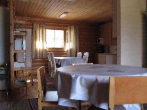 a dining room with a table and chairs and a kitchen at Holiday Home Korvenniemi by Interhome in Töfsala