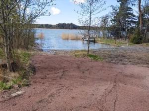 uma estrada de terra ao lado de um corpo de água em Holiday Home Korvenniemi by Interhome em Töfsala