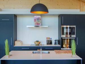 una cocina con fregadero y estufa horno superior en Chalet D'Arby by Interhome, en Nendaz