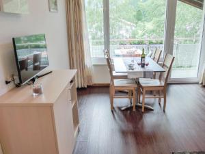 a dining room with a table and chairs and a window at Apartment Amici-1 by Interhome in Saas-Grund