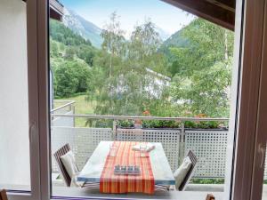 a table and chairs on a balcony with a view at Apartment Amici-1 by Interhome in Saas-Grund