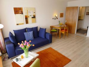 ein Wohnzimmer mit einem blauen Sofa und einem Tisch in der Unterkunft Apartment Promenade - Utoring-59 by Interhome in Arosa