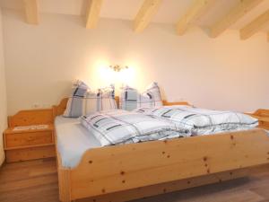 1 dormitorio con cama de madera y almohadas azules y blancas en Apartment Steinernes Meer by Interhome, en Saalfelden am Steinernen Meer