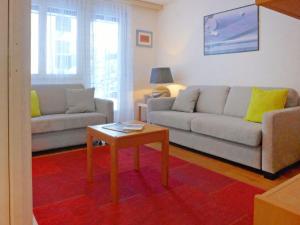 ein Wohnzimmer mit 2 Sofas und einem Couchtisch in der Unterkunft Apartment Roger-1 by Interhome in Zermatt