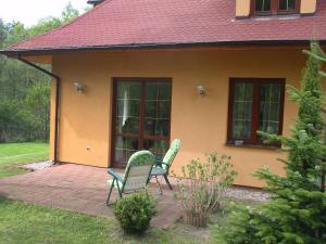 2 chaises assises sur une terrasse en face d'une maison dans l'établissement Holiday Home Borowikowa by Interhome, à Sasino