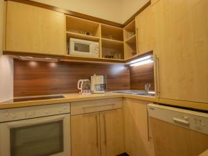 a kitchen with wooden cabinets and a microwave at Apartment Alpin-7 by Interhome in Sölden