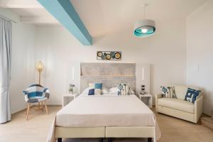 a bedroom with a large bed and a chair at Hotel Ristorante La Conchiglia in Cala Gonone