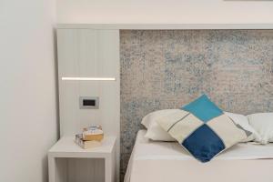 a bedroom with a bed with a blue and white pillow at Hotel Ristorante La Conchiglia in Cala Gonone