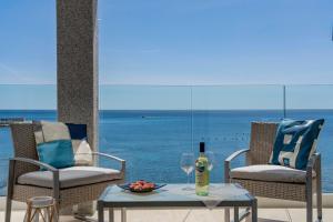a table with a glass of wine and two chairs at Hotel Ristorante La Conchiglia in Cala Gonone