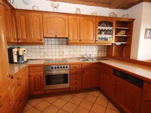 a kitchen with wooden cabinets and a sink at Apartment Eisele by Interhome in Kirchberg bei Mattighofen