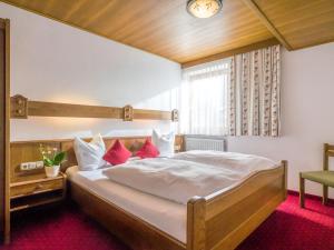 マウラッハにあるApartment Christian-1 by Interhomeのベッドルーム1室(白いシーツと赤い枕の大型ベッド1台付)