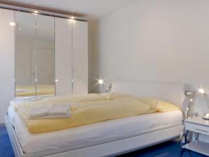 ein Schlafzimmer mit einem großen Bett und einem Spiegel in der Unterkunft Apartment Goldenhorn by Interhome in Wengen