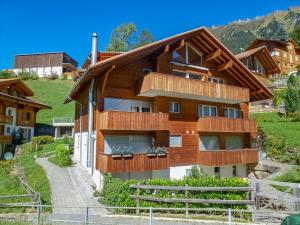 a house in the mountains with a wooden roof at Apartment Goldenhorn Apt-F by Interhome in Wengen