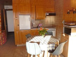 een keuken met een tafel met daarop een vaas met bloemen bij Apartment Centaure A RS 3 by Interhome in Ovronnaz