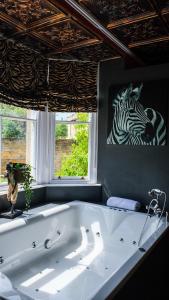 a bath tub in a room with a zebra painting on the wall at St Hildas Complex in Hinderwell