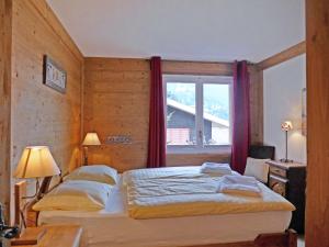 a bedroom with two beds and a window at Apartment Sulegg by Interhome in Wengen