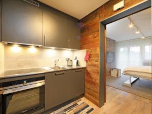 Apartment Grillon-3 by Interhome في زيرمات: مطبخ مع مغسلة وسرير في غرفة