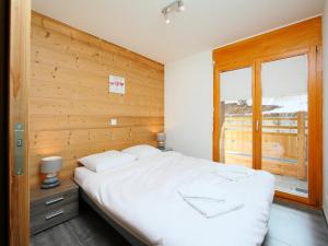 ナンダにあるApartment la Ferme de Sandra F0 by Interhomeの木製の壁のベッドルーム1室(白い大型ベッド1台付)
