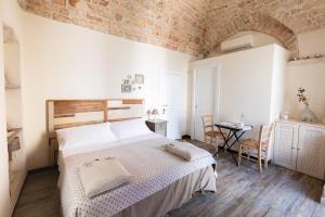 a bedroom with a large bed and a brick wall at Camere Caroseno in Castellana Grotte