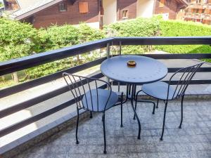 a table and two chairs sitting on a balcony at Apartment Villars Soleil B15 by Interhome in Villars-sur-Ollon