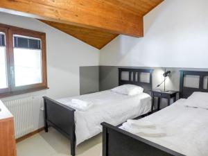 a bedroom with two beds and a window at Apartment Villars Soleil B15 by Interhome in Villars-sur-Ollon