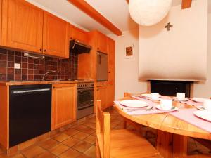una cocina con una mesa de madera y un aparato negro en Apartment Zodiaque RS 4 by Interhome, en Ovronnaz