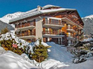 a large building with snow in front of it at Apartment Galaxie 110 by Interhome in Verbier