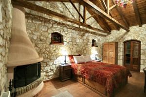 a bedroom with a bed and a stone wall at Archontiko Kolokotroni in Stemnitsa