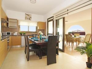 een keuken en eetkamer met een tafel en stoelen bij Villa merry by Interhome in Ayia Napa